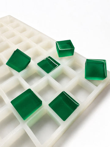Molde para gomitas cuadradas de 6 mL, 165 cavidades — vista lateral en ángulo; gomitas cuadradas translúcidas verde esmeralda; fondo blanco